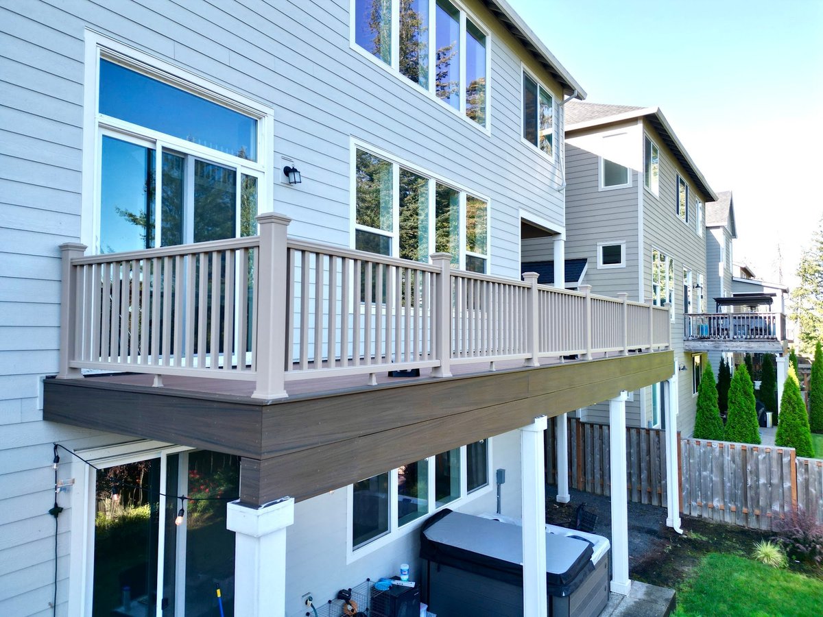 Second-story composite deck with a tan composite railing system and white support columns