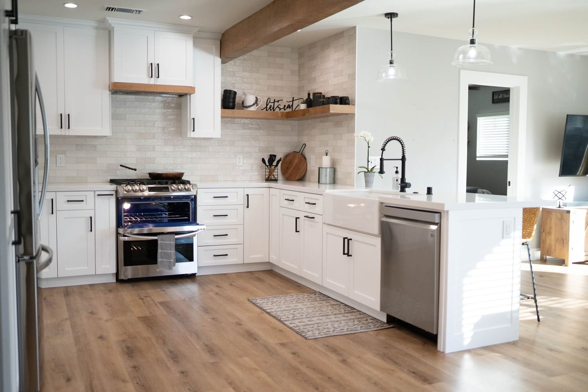 Open-plan kitchen and living area under an exposed wood beam where a wall was removed