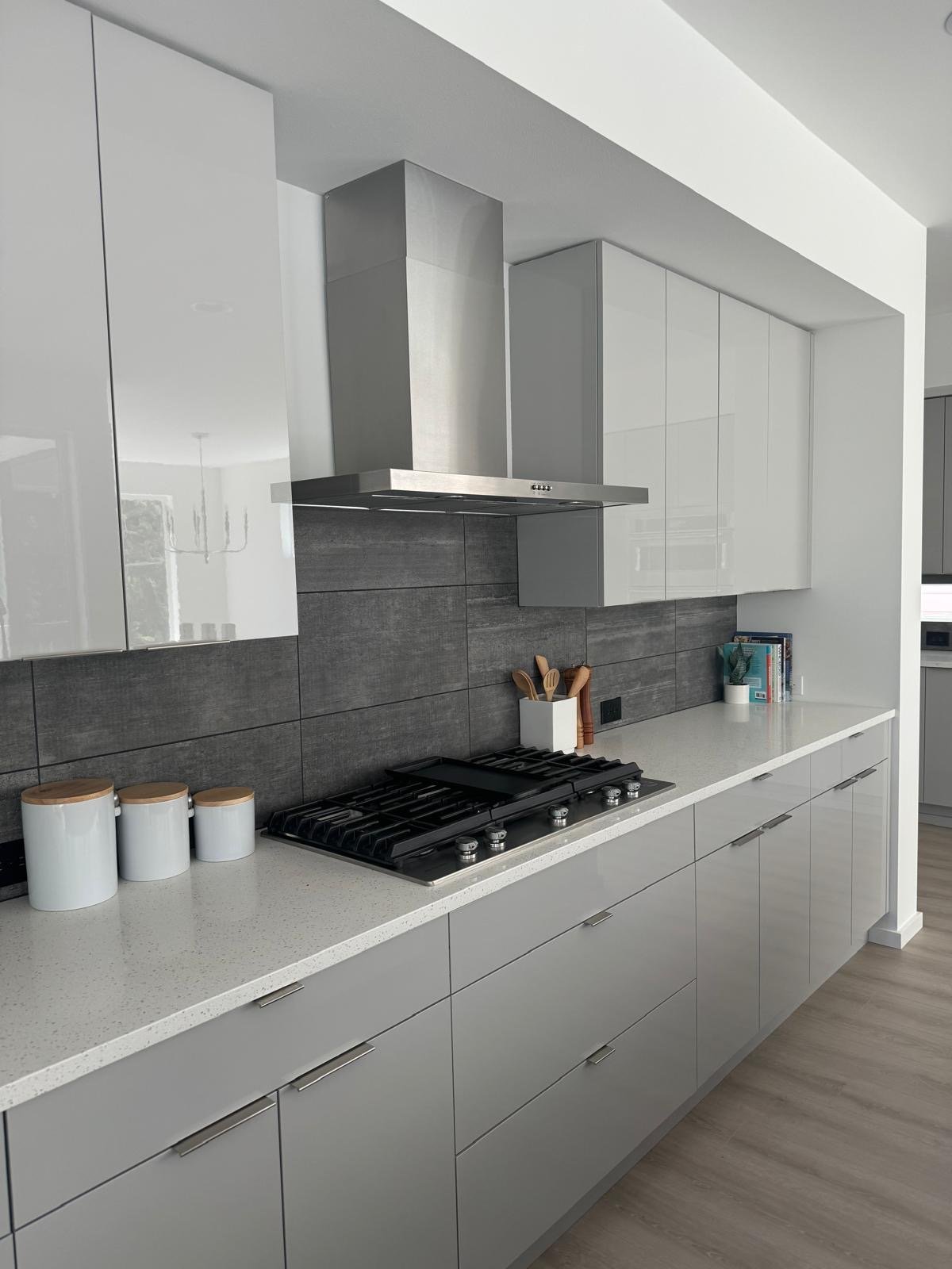 Modern kitchen with high-gloss flat-panel cabinets, gray tile backsplash and gas cooktop
