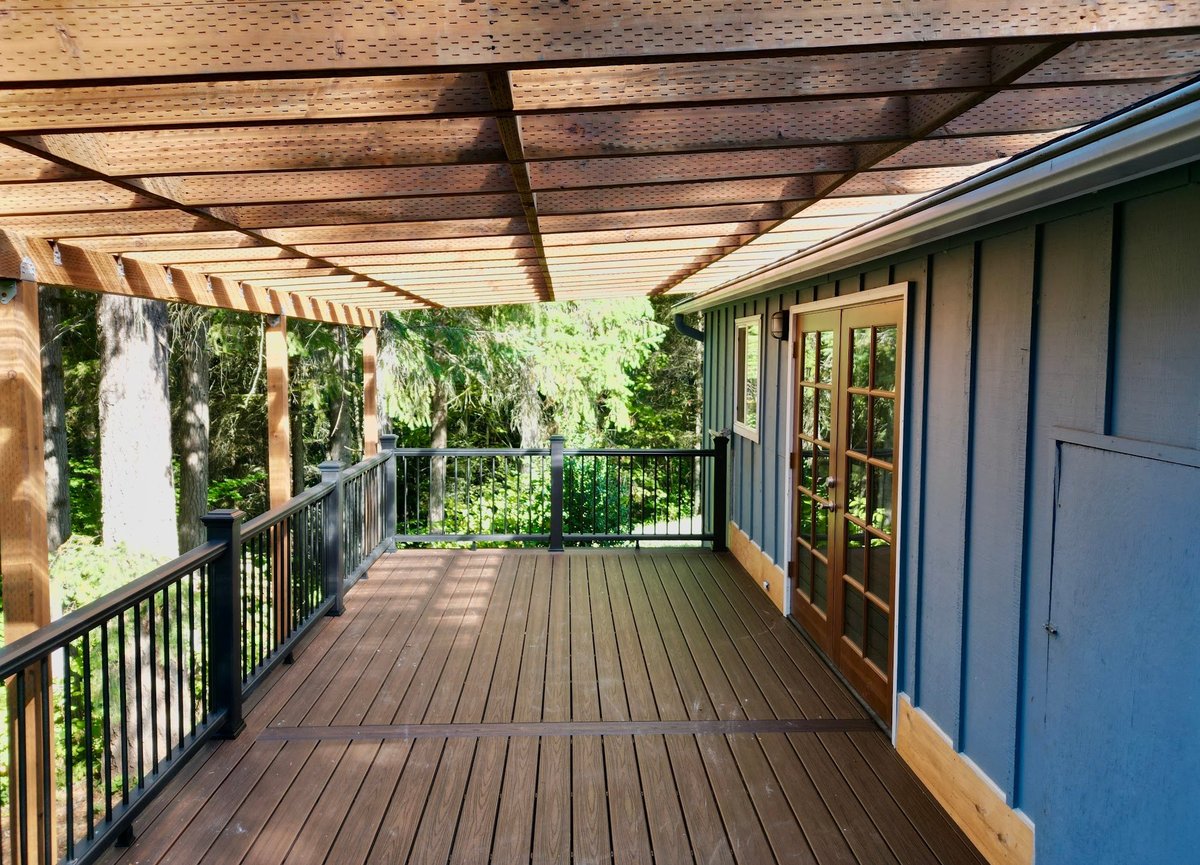 Covered deck with a timber pergola roof, black metal railings and French doors