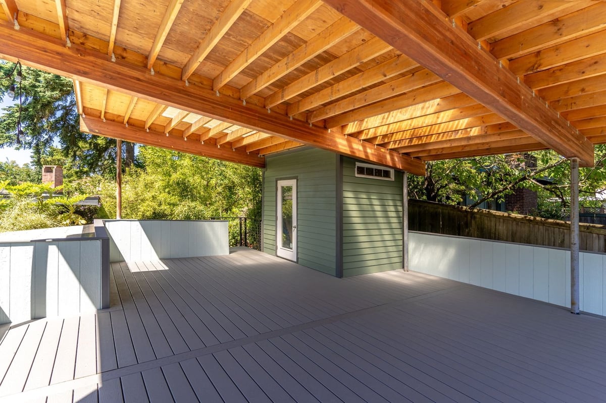 Large covered outdoor structure with exposed timber framing over a composite deck