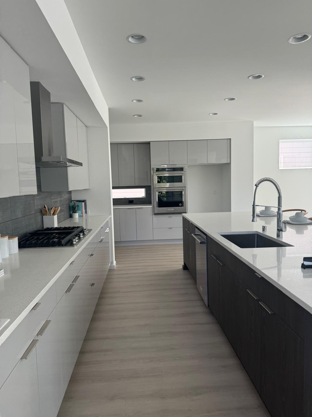 Minimal galley kitchen with flat-panel cabinets and a long dark wood island with sink