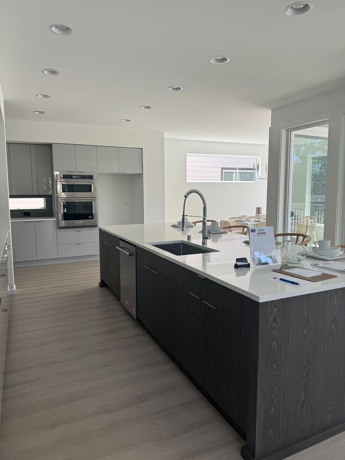 Modern galley kitchen with flat-panel gray cabinets, a dark wood island and quartz countertops