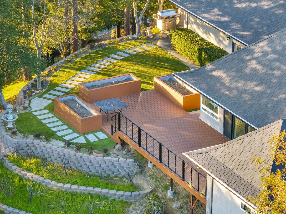 Aerial view of a composite deck with cable railing, built-in planters and terraced retaining walls