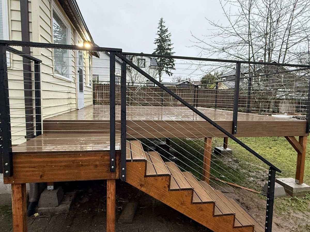 Elevated deck with visible posts, beams and new stairs with cable railing