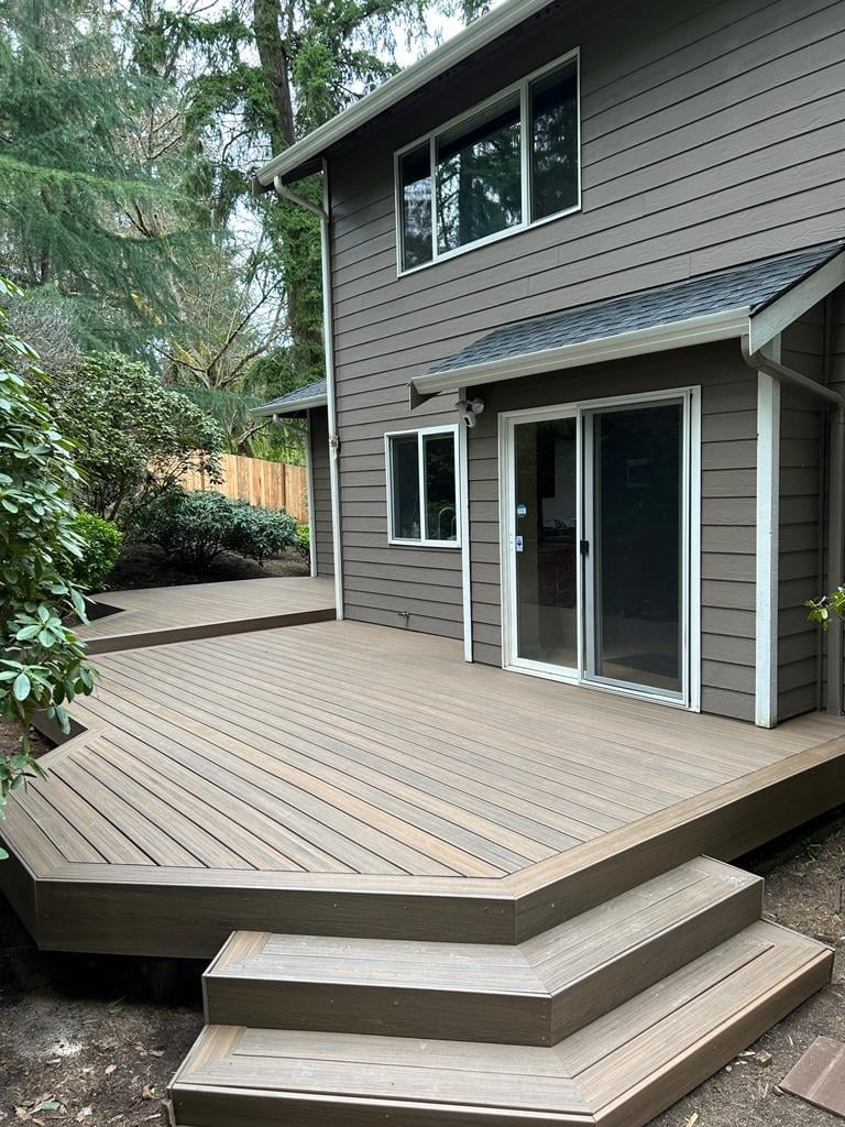 Composite deck wrapping a two-story home with wide angled steps