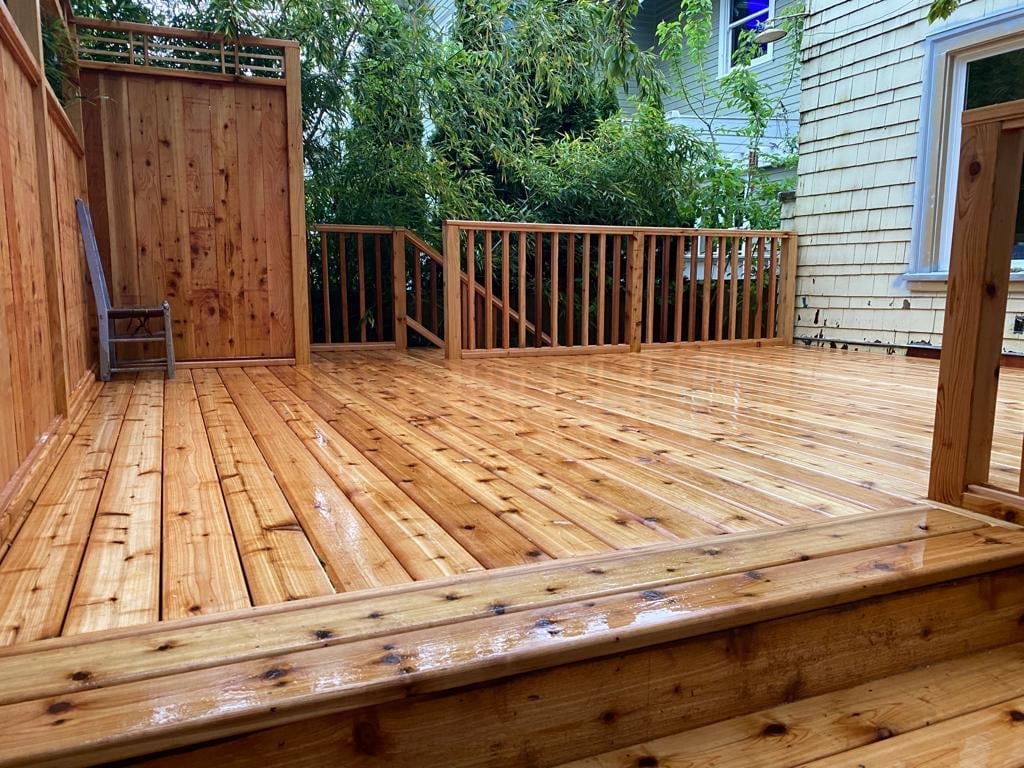 Newly built cedar deck with wood railings and a privacy screen